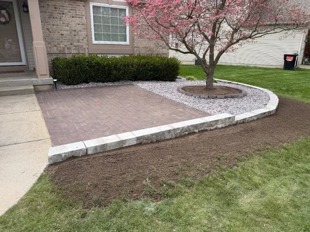 Brick paver patio with stone retaining wall and steps, hardscape installation by Jack of All Blades Landscaping in Grand Rapids MI